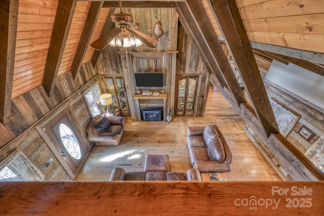 164 Avery County High School Rd, Newland, NC 28657 - unfurnished living room with wooden walls, a fireplace, a ceiling fan, hardwood / wood-style floors, and beamed ceiling