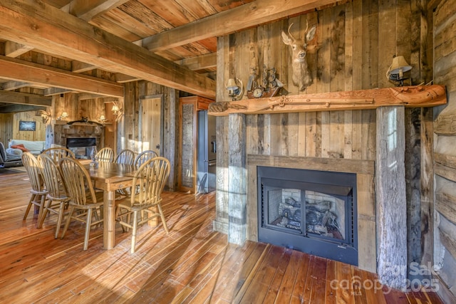 164 Avery County High School Rd, Newland, NC 28657 - dining room with a fireplace, wooden walls, hardwood / wood-style flooring, and wood ceiling with exposed beams