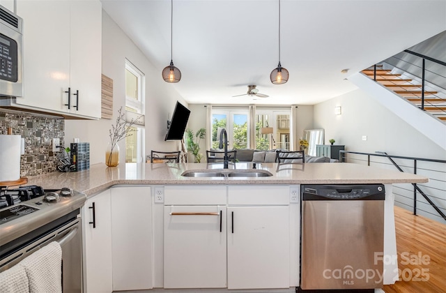 925 Westbrook Dr Unit B, Charlotte, NC 28202 - kitchen with stainless steel appliances, a sink, ceiling fan, white cabinets, and light wood-style floors