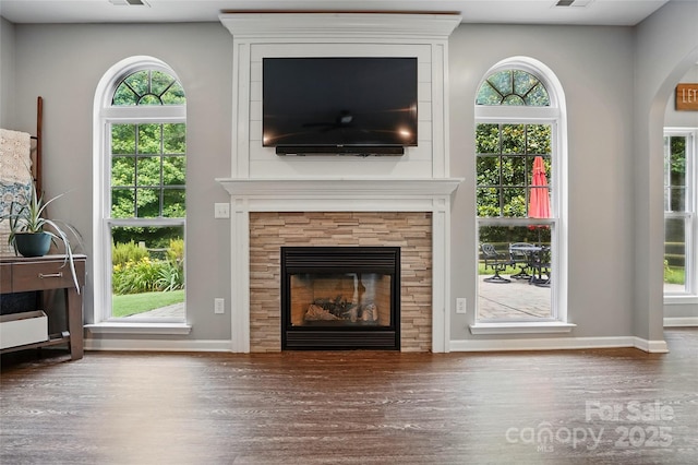 147 Whitley Mills Rd, Fort Mill, SC 29708 - unfurnished living room featuring wood finished floors, a glass covered fireplace, baseboards, and plenty of natural light