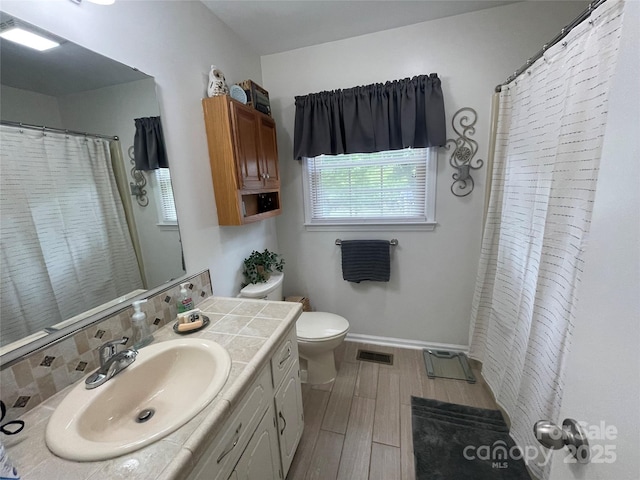 311 Tiffany St NW, Concord, NC 28027 - full bath featuring vanity, toilet, wood finished floors, baseboards, and curtained shower