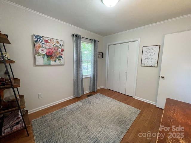 311 Tiffany St NW, Concord, NC 28027 - bedroom with wood finished floors, a closet, crown molding, and baseboards