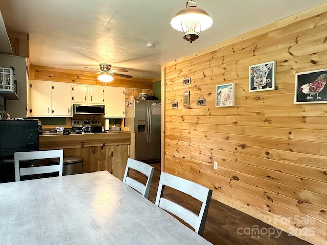 3503 Wyndham Ln, Lenoir, NC 28645 - dining area with ceiling fan, wooden walls, and dark wood-style floors