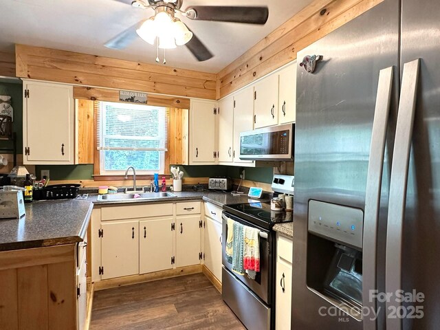 3503 Wyndham Ln, Lenoir, NC 28645 - kitchen with appliances with stainless steel finishes, a sink, dark countertops, dark wood-style floors, and white cabinets