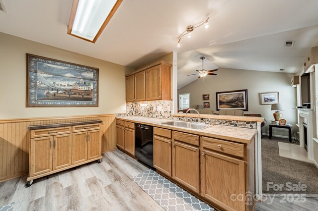 199 Ashmont Dr, Kannapolis, NC 28081 - kitchen with black dishwasher, a peninsula, a sink, ceiling fan, and wainscoting
