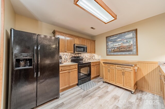 199 Ashmont Dr, Kannapolis, NC 28081 - kitchen with black appliances, light wood finished floors, wainscoting, light countertops, and decorative backsplash
