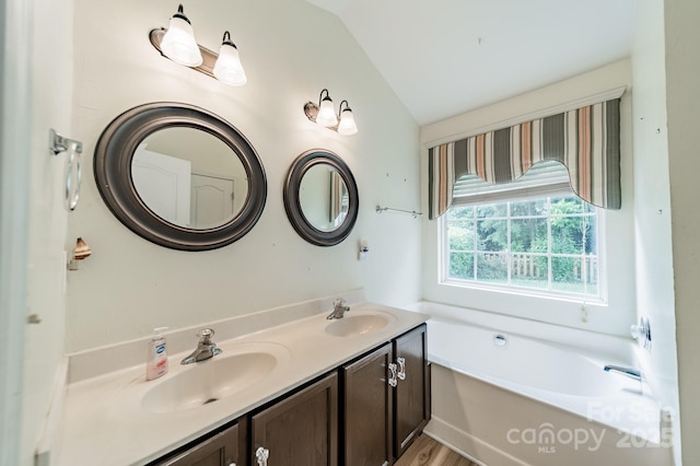 199 Ashmont Dr, Kannapolis, NC 28081 - bathroom featuring a garden tub, lofted ceiling, and double vanity