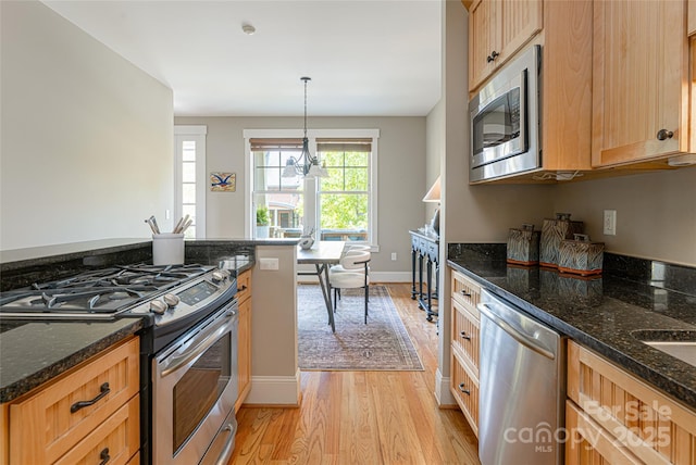 4 Fitzgerald Rd, Black Mountain, NC 28711 - kitchen with stainless steel appliances, light wood finished floors, dark stone countertops, hanging light fixtures, and baseboards