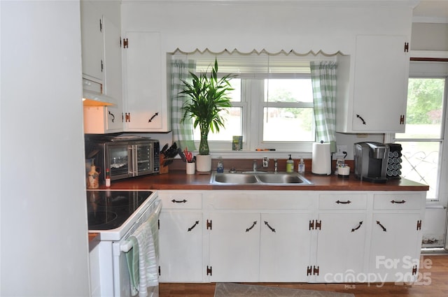 3505 Valley Dr, Chester, SC 29706 - kitchen with white range with electric cooktop, a sink, ventilation hood, dark countertops, and white cabinetry