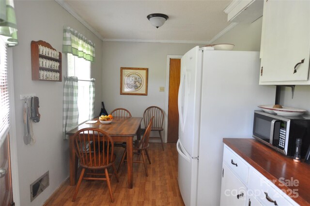 3505 Valley Dr, Chester, SC 29706 - kitchen featuring stainless steel microwave, light wood-type flooring, crown molding, white cabinets, and freestanding refrigerator