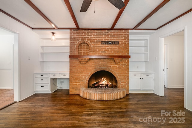 5926 Sharon Rd, Charlotte, NC 28210 - unfurnished living room with built in shelves, beam ceiling, dark wood-style floors, a ceiling fan, and a fireplace