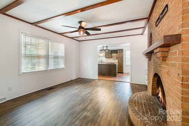 5926 Sharon Rd, Charlotte, NC 28210 - unfurnished living room featuring wood finished floors, a ceiling fan, a fireplace, beam ceiling, and a sink