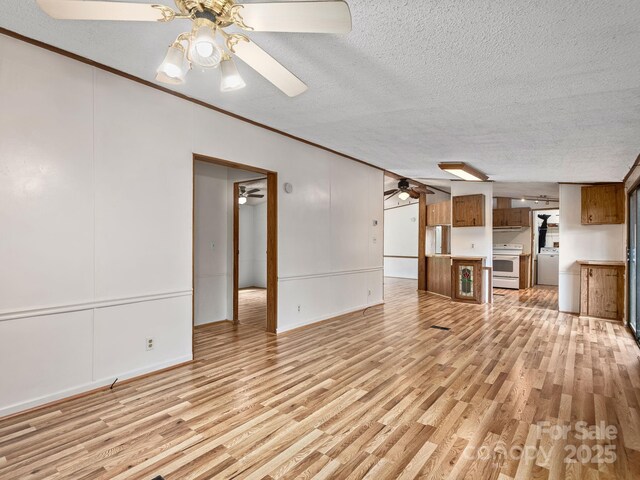 32 Lake Eden Cir, Black Mountain, NC 28711 - unfurnished living room featuring ceiling fan, a textured ceiling, light wood-style flooring, crown molding, and washer / clothes dryer