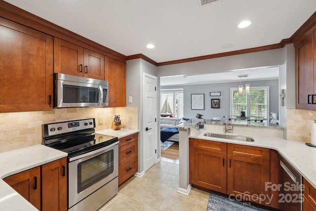 635 Portside Dr, Davidson, NC 28036 - kitchen with stainless steel appliances, a sink, crown molding, a peninsula, and recessed lighting