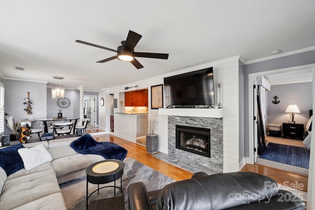 635 Portside Dr, Davidson, NC 28036 - living area featuring light wood-style flooring, crown molding, ceiling fan, baseboards, and a high end fireplace
