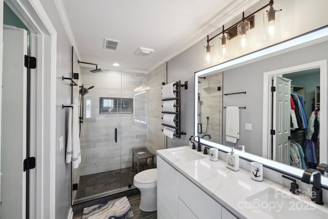 635 Portside Dr, Davidson, NC 28036 - full bathroom featuring a shower stall, ornamental molding, double vanity, a walk in closet, and toilet