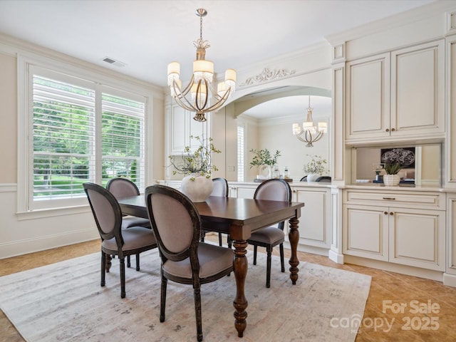 5805 Copperleaf Commons Ct, Charlotte, NC 28277 - dining space featuring a chandelier, arched walkways, crown molding, light tile patterned floors, and a decorative wall