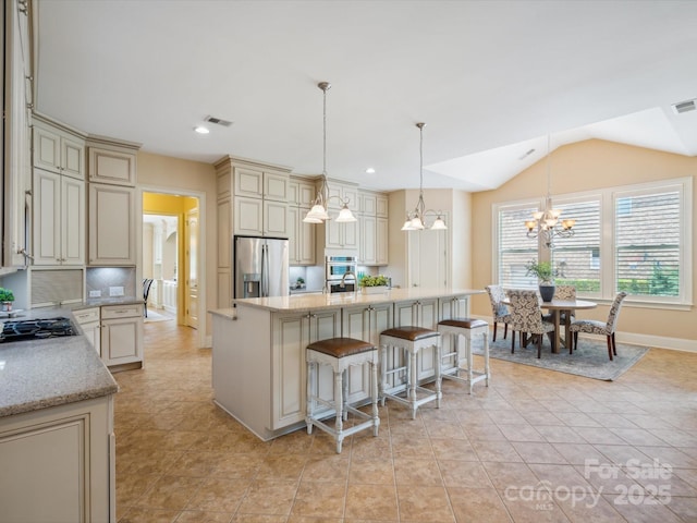 5805 Copperleaf Commons Ct, Charlotte, NC 28277 - kitchen with cream cabinetry, stainless steel appliances, a chandelier, tasteful backsplash, and light stone counters