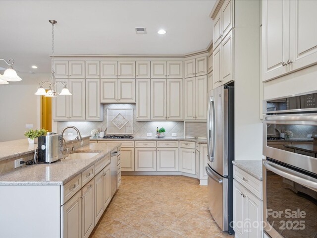 5805 Copperleaf Commons Ct, Charlotte, NC 28277 - kitchen featuring stainless steel appliances, cream cabinetry, decorative backsplash, recessed lighting, and light stone countertops