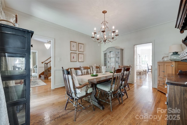 10215 Balmoral Cir, Charlotte, NC 28210 - dining space with stairs, light wood-style flooring, ornamental molding, and a chandelier