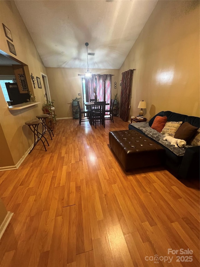 5816 Rocky Mount Ct, Charlotte, NC 28214 - living area with vaulted ceiling, light wood-style floors, and baseboards