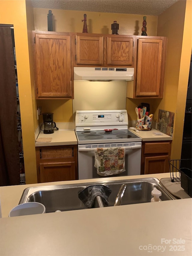 5816 Rocky Mount Ct, Charlotte, NC 28214 - kitchen featuring electric stove, under cabinet range hood, light countertops, and brown cabinets