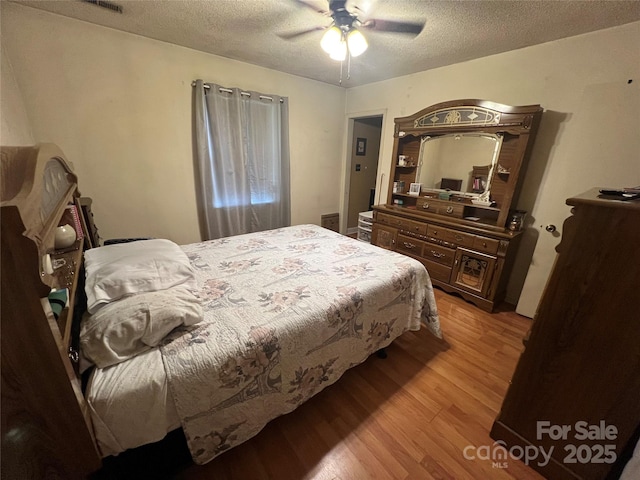 5816 Rocky Mount Ct, Charlotte, NC 28214 - bedroom featuring light wood-style flooring, a textured ceiling, and a ceiling fan
