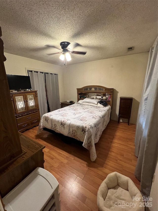 5816 Rocky Mount Ct, Charlotte, NC 28214 - bedroom featuring light wood finished floors, ceiling fan, and a textured ceiling