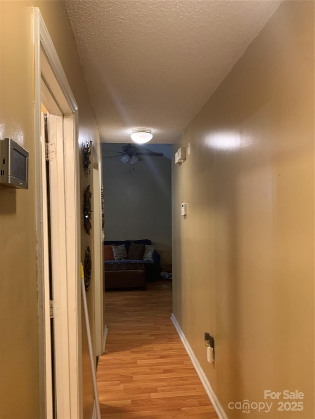 5816 Rocky Mount Ct, Charlotte, NC 28214 - hallway featuring a textured ceiling, light wood-type flooring, and baseboards