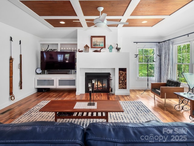1165 Mountain Laurel Dr, Columbus, NC 28722 - living room with ceiling fan, baseboards, a brick fireplace, wood finished floors, and beam ceiling