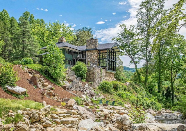 400 Kings Dr, Lake Lure, NC 28746 - view of side of property featuring stairway, stone siding, a sunroom, and a chimney