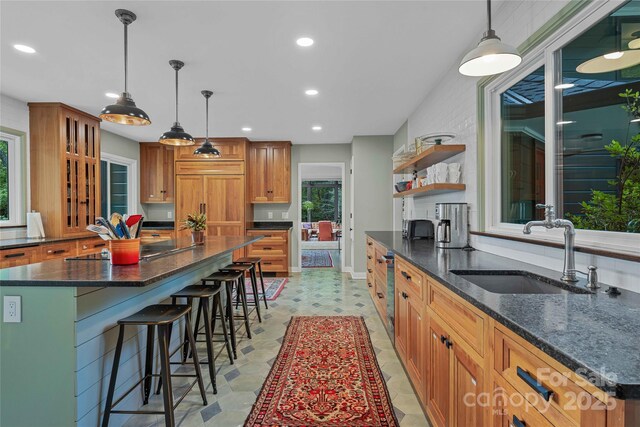 400 Kings Dr, Lake Lure, NC 28746 - kitchen with a sink, brown cabinetry, recessed lighting, a kitchen bar, and paneled refrigerator