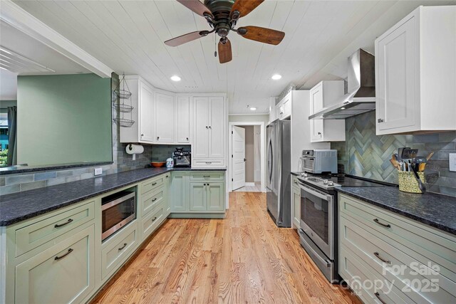 400 Kings Dr, Lake Lure, NC 28746 - kitchen featuring wall chimney range hood, appliances with stainless steel finishes, light wood-style floors, decorative backsplash, and wooden ceiling