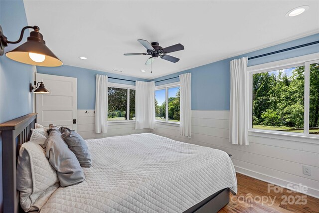 400 Kings Dr, Lake Lure, NC 28746 - bedroom featuring multiple windows, a wainscoted wall, wood finished floors, a ceiling fan, and recessed lighting