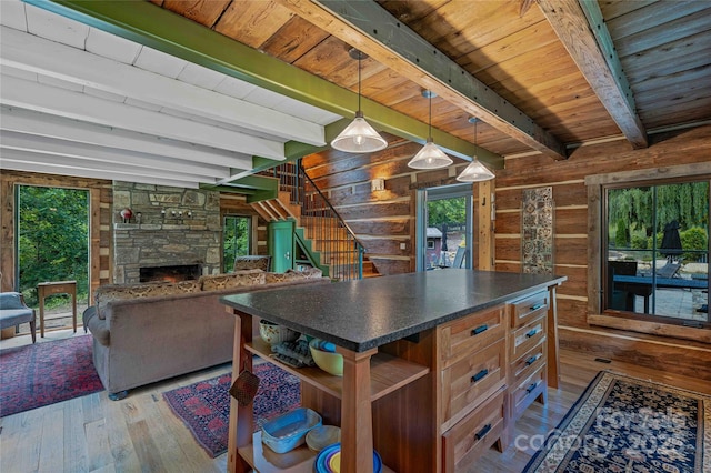 400 Kings Dr, Lake Lure, NC 28746 - kitchen featuring hardwood / wood-style floors, open shelves, dark countertops, wooden walls, and a stone fireplace