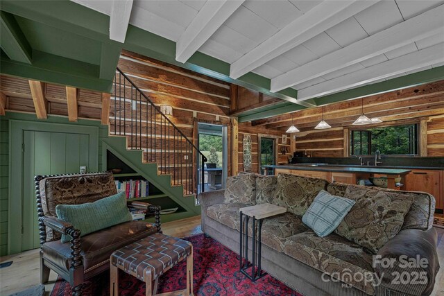 400 Kings Dr, Lake Lure, NC 28746 - living room with beamed ceiling, wooden walls, stairway, and wood finished floors