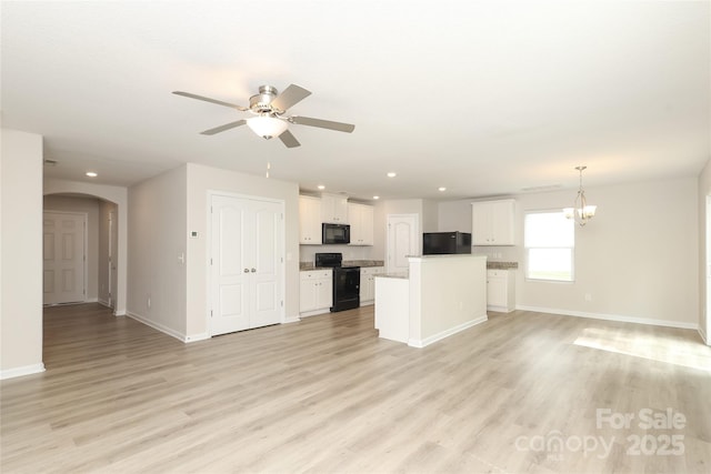 3349 Ellingford Rd, Charlotte, NC 28214 - unfurnished living room with baseboards, arched walkways, a ceiling fan, light wood-style flooring, and recessed lighting