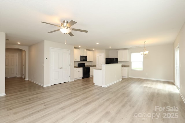 3349 Ellingford Rd, Charlotte, NC 28214 - unfurnished living room with baseboards, arched walkways, ceiling fan, recessed lighting, and a chandelier