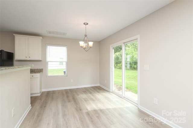 3349 Ellingford Rd, Charlotte, NC 28214 - unfurnished dining area with light wood-type flooring, a chandelier, and baseboards
