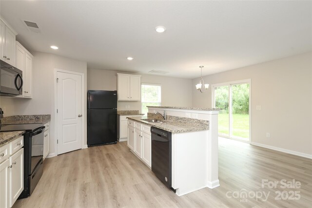 3349 Ellingford Rd, Charlotte, NC 28214 - kitchen with black appliances, a sink, light wood-style floors, a chandelier, and recessed lighting
