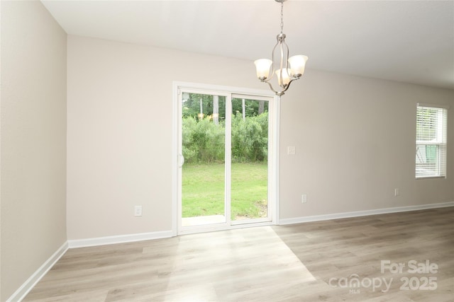 3349 Ellingford Rd, Charlotte, NC 28214 - spare room featuring a chandelier, light wood finished floors, and baseboards