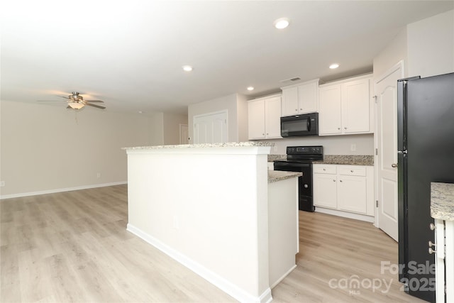 3349 Ellingford Rd, Charlotte, NC 28214 - kitchen with black appliances, light wood-type flooring, ceiling fan, white cabinets, and a kitchen island