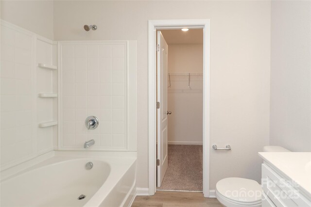 3349 Ellingford Rd, Charlotte, NC 28214 - bathroom with wood finished floors, toilet, vanity, a walk in closet, and baseboards