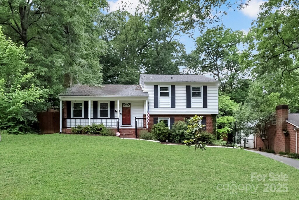 3624 Moultrie St, Charlotte, NC 28209 - split level home featuring covered porch, a front lawn, and brick siding