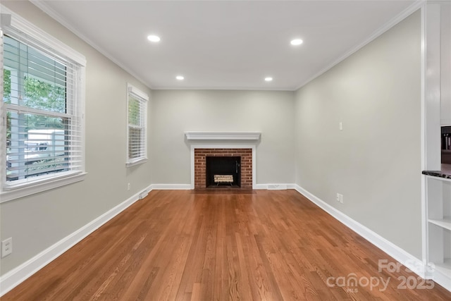 3624 Moultrie St, Charlotte, NC 28209 - unfurnished living room featuring wood finished floors, crown molding, a brick fireplace, baseboards, and recessed lighting