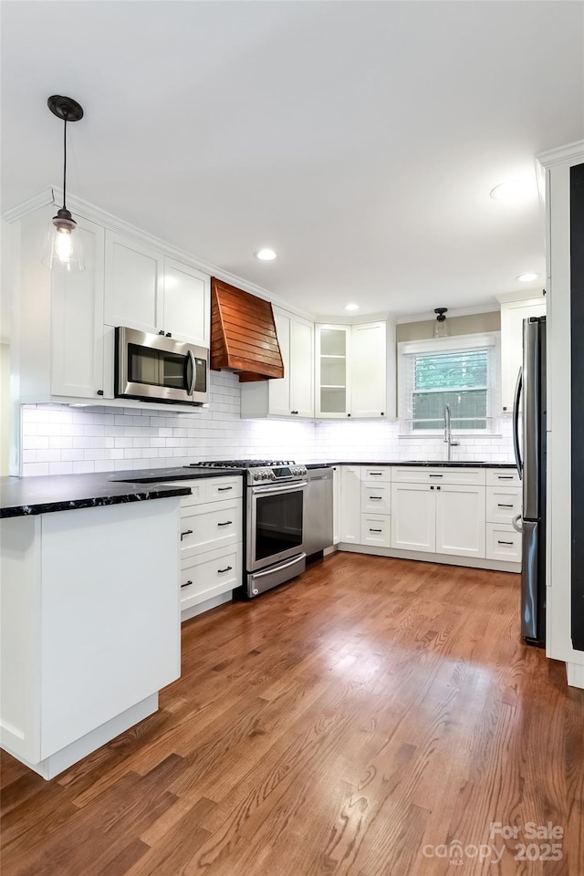 3624 Moultrie St, Charlotte, NC 28209 - kitchen featuring appliances with stainless steel finishes, premium range hood, white cabinets, backsplash, and recessed lighting