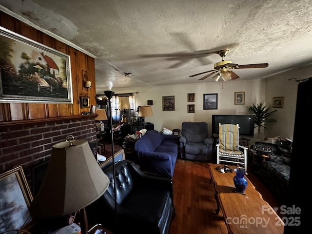 537 Beall St NW, Lenoir, NC 28645 - living area featuring a textured ceiling, wood finished floors, a ceiling fan, and wood walls