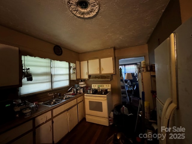 537 Beall St NW, Lenoir, NC 28645 - kitchen with white range oven, a sink, a textured ceiling, dark wood-style flooring, and dark countertops