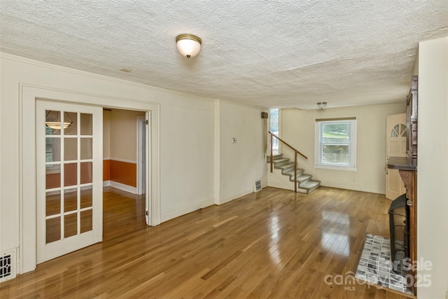 20 Kenilwood Pl, Asheville, NC 28803 - unfurnished living room featuring wood finished floors, stairway, a textured ceiling, and baseboards