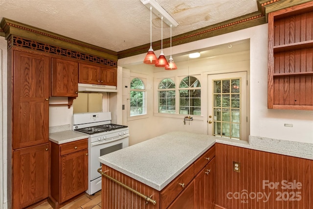 20 Kenilwood Pl, Asheville, NC 28803 - kitchen featuring white range with gas cooktop, light countertops, a textured ceiling, under cabinet range hood, and brown cabinets